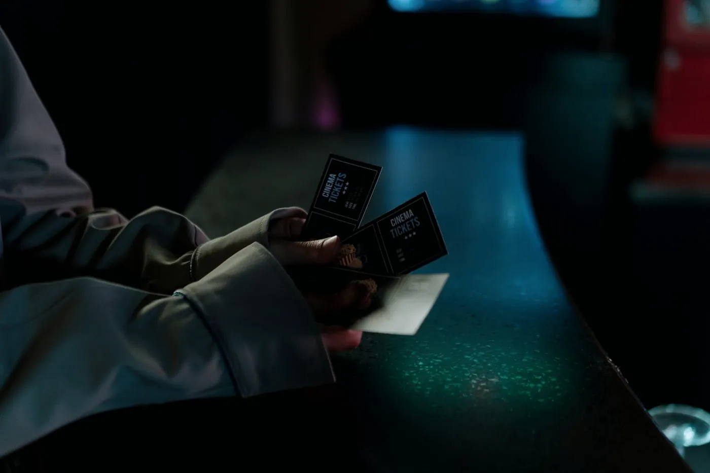 Hands holding event tickets at night